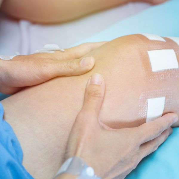 a person holding his knee strapped with tape